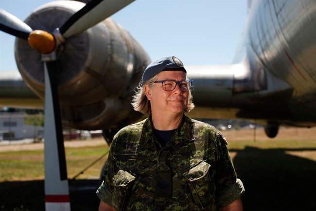 Master Cpl. Natalie Murray, who works at the instrument flight rules control centre at CFB Comox, poses for a photograph beside the Canadair CL-28 Argus Mark 1 at Heritage Air Park near the base in Comox, B.C., Friday, July 29, 2016. 
