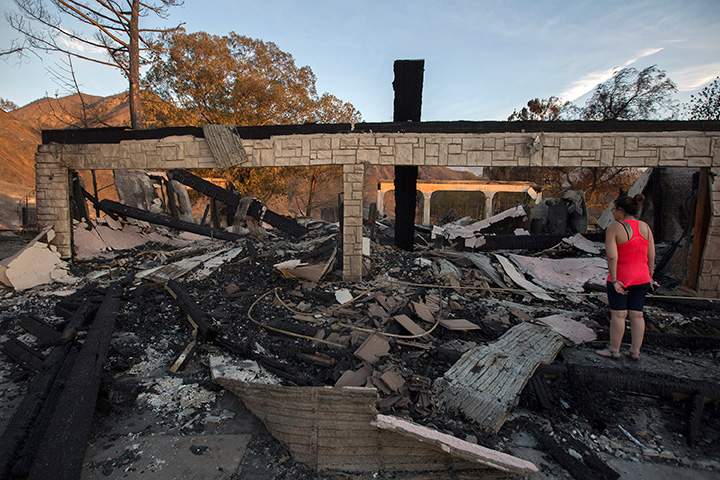 Residents and family members return to a home that was destroyed in the Sand Fire on July 25, 2016 in Santa Clarita, California.