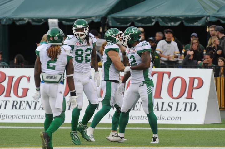 Saskatchewan Roughriders players Curtis Steele (#2), Naaman Roosevelt (#82) and John Chiles (#12) celebrate in the endzone during the 1st quarter of CFL game action between the Edmonton Eskimos and the Saskatchewan Roughriders on Friday, July 08, 2016.