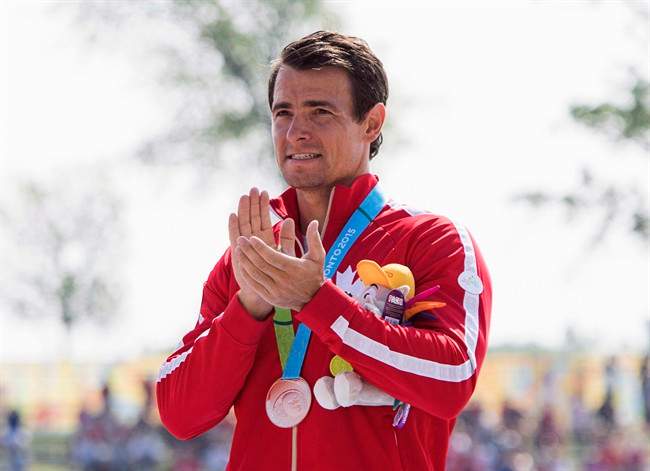 Canadian star kayaker Adam van Koeverden claps accepting his bronze medal for the K1 1000m final at the 2015 Pan Am Games in Welland, Ont., in a July 13, 2015, file photo.