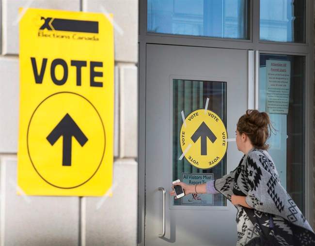 A woman enters Maple High School in Vaughan, Ont., to cast her vote in the Canadian federal election on Monday, Oct. 19, 2015. Elections Canada officials admit they were overwhelmed by the length of last year's federal election campaign.