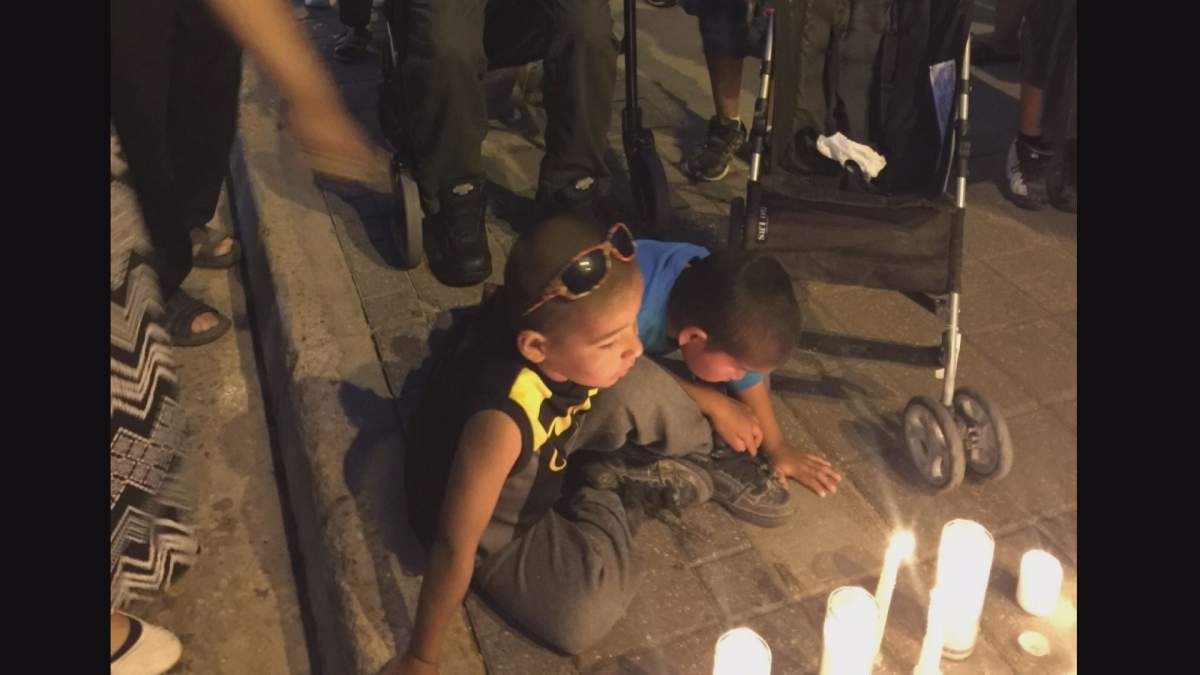 Cyril Weenusk’s children gather at a vigil outside the MTS Centre in Winnipeg.