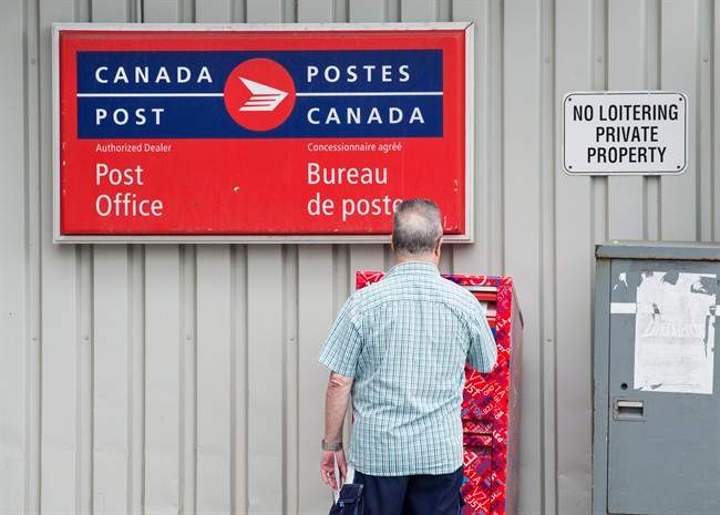 A man mails a letter outside a Canada Post office in Halifax on Wednesday, July 6, 2016. Darren Calabrese/The Canadian Press.