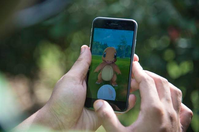a pair of hands hold a cellphone with the game Pokemon Go on the screen
