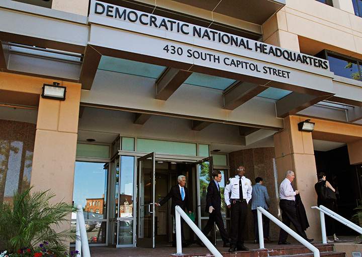 People stand outside the Democratic National Committee headquarters in Washington, Tuesday, June 14, 2016. 