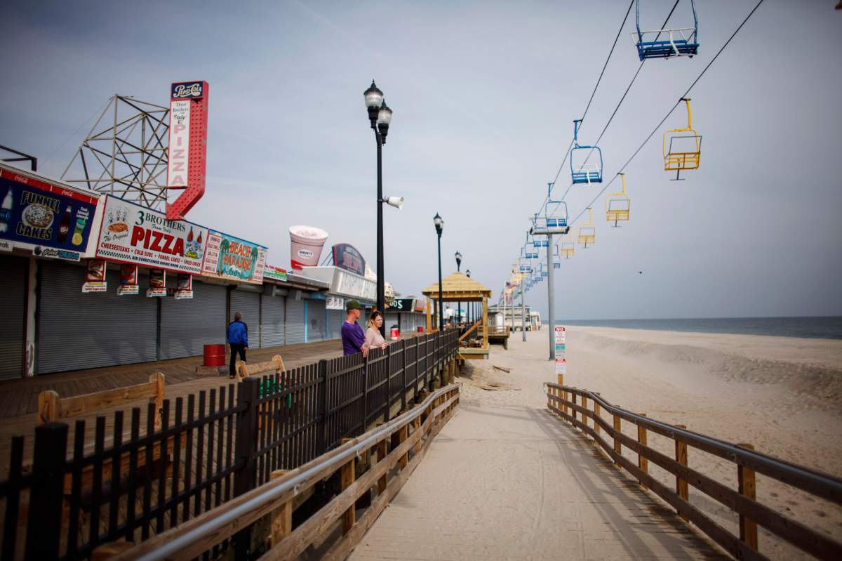 People stand on the Seaside Heights boardwalk  two years after Hurricane Sandy on October 29, 2014. Hurricane Sandy was recorded as the deadliest and most destructive hurricane of the 2012 Atlantic hurricane season. 