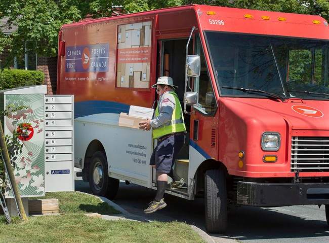 A Canada Post employee fills a community mail box in Dartmouth, N.S. on Thursday, June 30, 2016. 