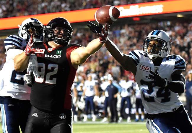 Toronto Argonauts' A.J. Jefferson (24) intercepts Ottawa Redblacks' Zack Evans (92) during first half CFL action in Ottawa on Sunday, July 31, 2016.