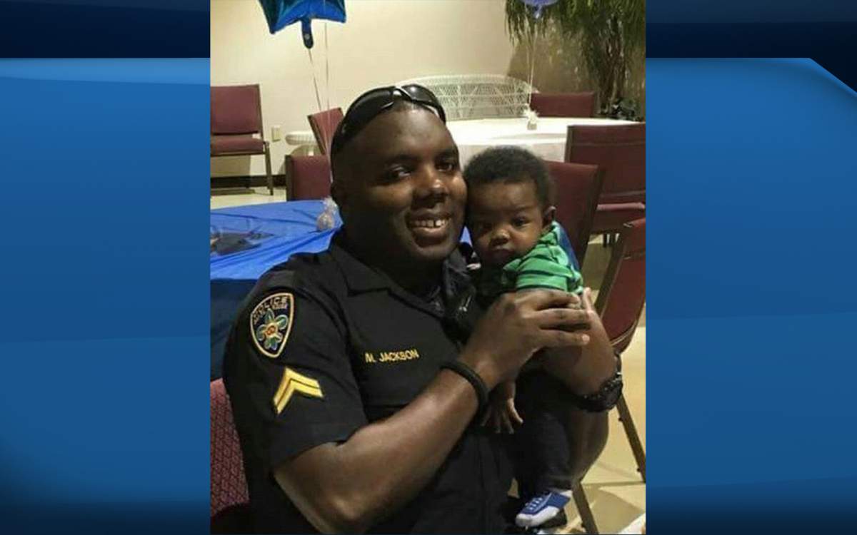 Baton Rouge Police Officer Montrell Jackson, holds his son Mason at a Father’s Day event for police officers in Baton Rouge, La.