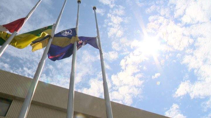 Flags fly at half-staff outside the city police station in Regina.