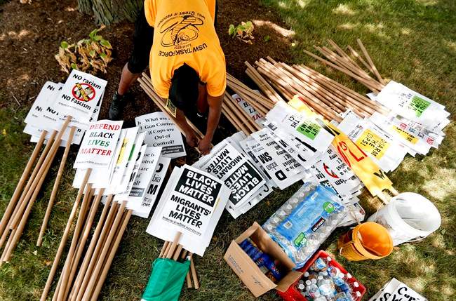 A demonstrator organizes protest signs, Sunday, July 17, 2016, in Cleveland, in preparation for the Republican National Convention that starts Monday. 