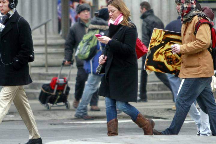 A file photo of a woman texting and walking.