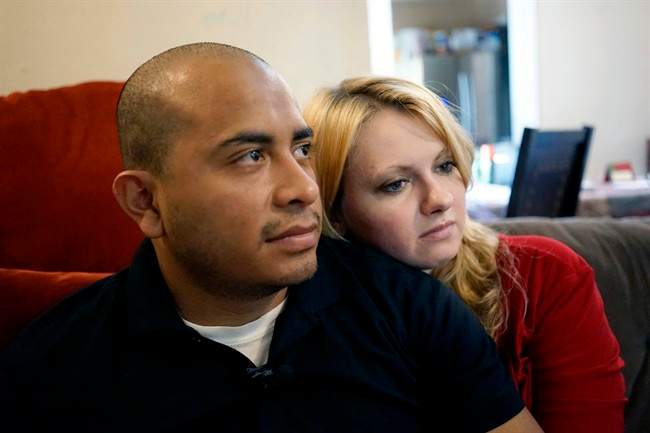 Dallas Police Department Officer Jorge Barrientos, left, is pictured recovering at his home with his girlfriend, Bethany Knutson, Sunday, July 10, 2016, in Dallas. Barrientos was shot in the hand and struck by shrapnel when a gunman attacked officers at a protest against police brutality July 7, 2016.