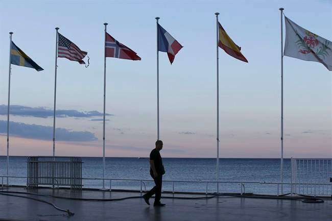 A security guard walks near the scene of an attack after a truck drove onto the sidewalk and plowed through a crowd of revelers who'd gathered to watch the fireworks in the French resort city of Nice, southern France, Friday, July 15, 2016.