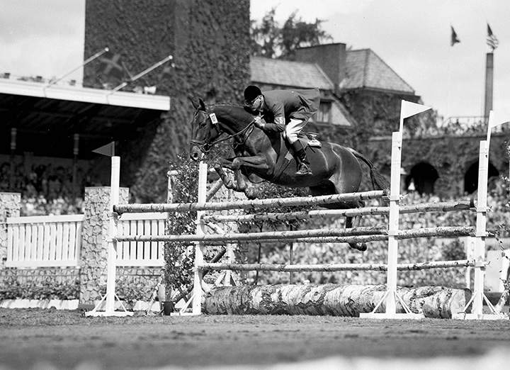 In this June 17, 1956 file photo, Frank Chapot, of the United States, clears a hurdle on his horse Bel Air during the first round of the Olympic Grand Prix in Stockholm, Sweden.