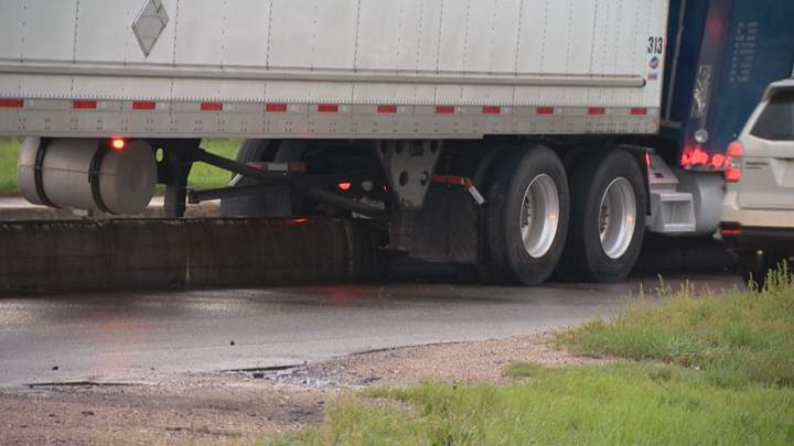 Crews are working to remove a semi that got hung-up on a 22nd Street barrier in Saskatoon.