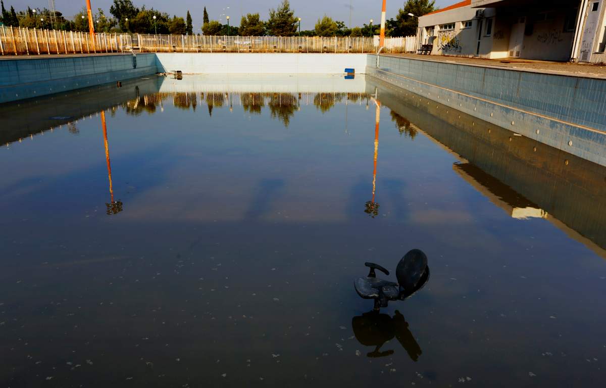 A chair stands in a deserted swimming pool at the Olympic Village in the town of Thrakomakedones, north of Athens July 25, 2014. REUTERS/Yannis Behrakis