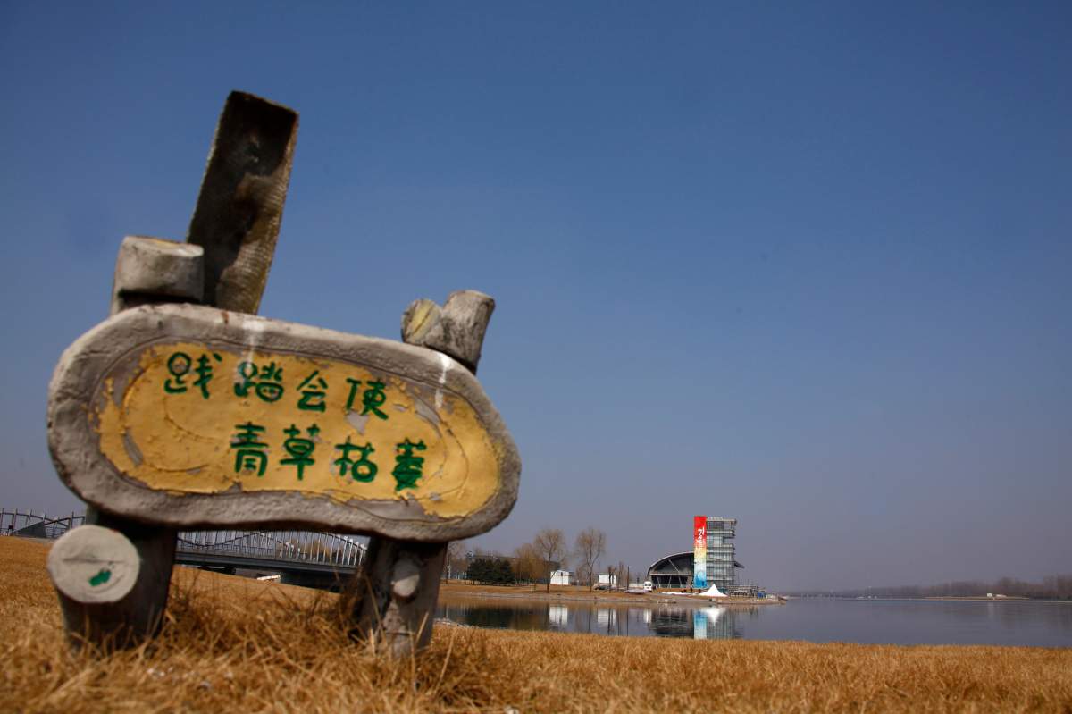 A sign that reads “Keep off the Grass” stands at the deserted and unmaintained former venue for the 2008 Beijing Olympic Games rowing competition, March 27, 2012. REUTERS/David Gray