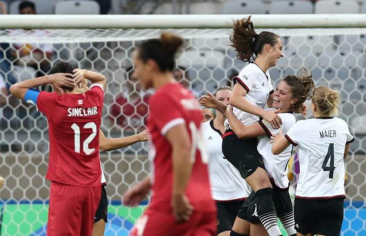 Canada’s Christine Sinclair reacts as Sara Daebritz of Germany celebrates her goal with teammates during semi-final action on August 16, 2016.
