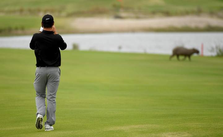 Danny Lee of New Zealand takes a photo of a capybara