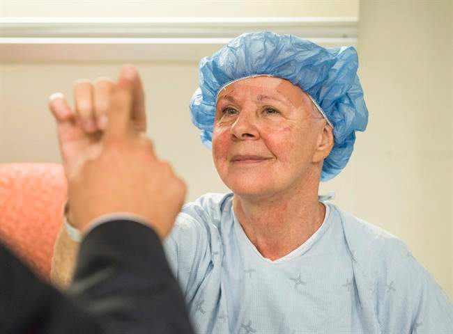 Noreen Smith of Bobcaygeon, Ont. tests out the steadiness of her hand with a neurosurgeon after undergoing an MRI-guided focused ultrasound for essential tremor, a common neurological condition that causes uncontrollable shaking, in a handout photo. 