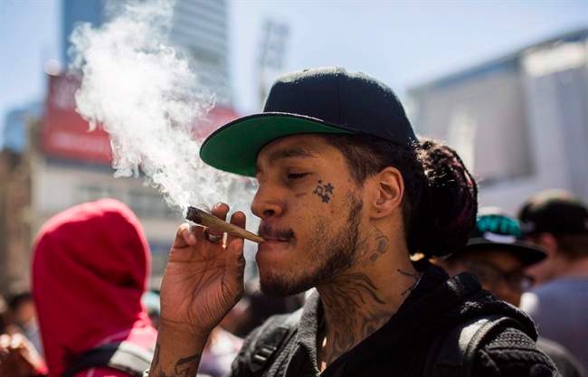 A man smokes a marijuana joint during the "420 Toronto" rally in Toronto, Wednesday April 20, 2016.