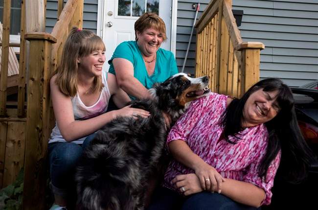 From left to right, Bronwyn Mengering, Dawn Mengering, and Debbie Johnson laugh while sitting with their dog Thor in Dartmouth, N.S. on Friday, August 19, 2016.