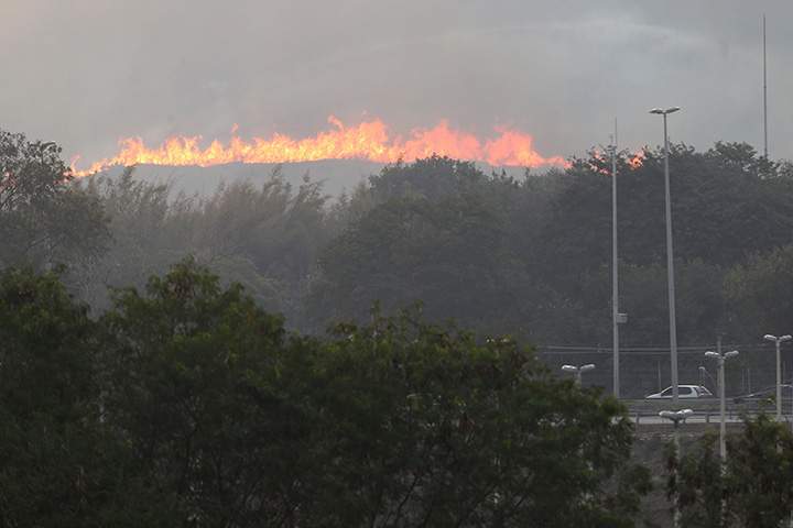 A wildfire burns in the nearby hills of Deodoro, near the Olympic mountain bike venue, on August 15, 2016 in Rio de Janeiro, Brazil.  
