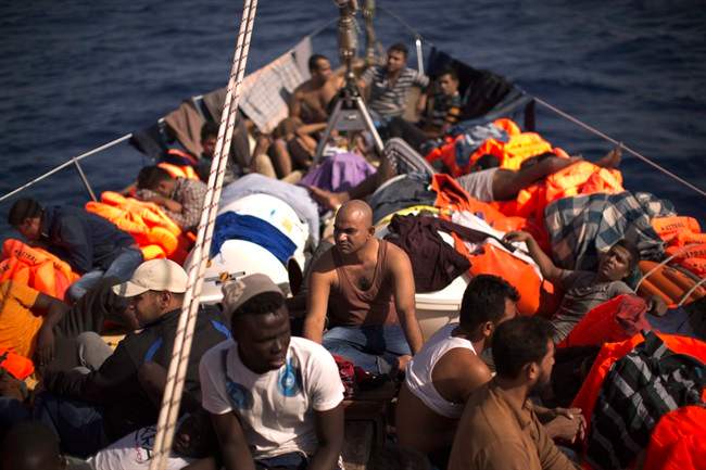 Migrants sit aboard a rescue boat after fleeing Libya, assisted by members of a Spanish NGO, during a rescue operation at the Mediterranean sea, about 25 miles north of Sabratha, Libya, Thursday, Aug. 18, 2016. At least three people have died on Thursday morning during the sinking of a wooden boat full with migrants as they tried to reach the Italian coasts. (AP Photo/Emilio Morenatti).