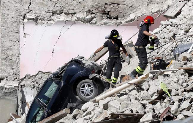 Rescuers make their way through destroyed houses following an earthquake in Italy, in August 2016. Some scientist believe climate change is triggering more earthquakes.