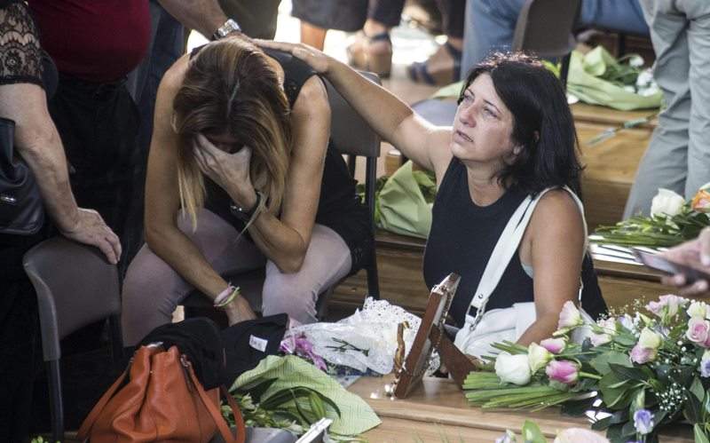 A relative of a victim cries in front of the coffin before the mass funeral for some of the victims of the earthquake that devastated central Italy on 24 August, in Ascoli Piceno, Marche region, Italy, 27 August 2016.