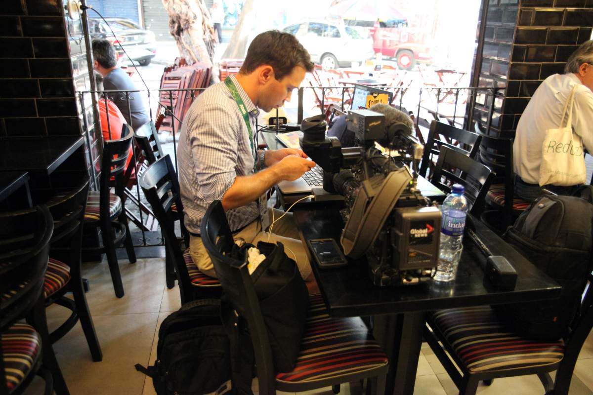Global News reporter Jeff Semple sets up shop in a restaurant in Saens Pena Square.