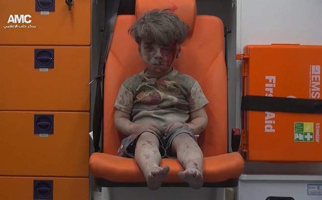 In this frame grab taken from video provided by the Syrian anti-government activist group Aleppo Media Center (AMC), a child sits in an ambulance after being pulled out or a building hit by an airstirke, in Aleppo, Syria, Wednesday, Aug. 17, 2016. Syrian opposition activists reported an airstrikes on the al-Qaterji neighborhood in Aleppo late Wednesday. (Aleppo Media Center via AP).