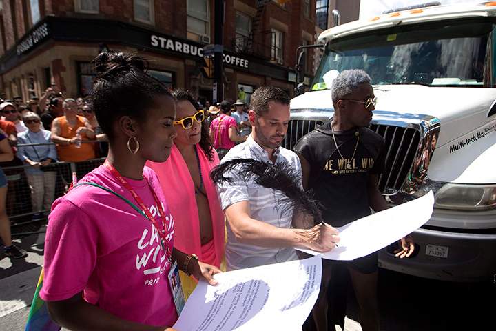Mathieu Chantelois signs a list of demands from the Black Lives Matters movement as they stage a sit-in at the annual Pride Parade in Toronto on Sunday, July 3, 2016.