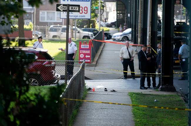 Sandals lay on a street corner at the crime scene, Saturday, Aug. 13, 2016, not far from the Al-Furqan Jame Masjid Mosque in the Ozone Park neighborhood of Queens, New York, where the leader of a New York City mosque has been fatally shot and an associate has been wounded in a brazen daylight attack.
