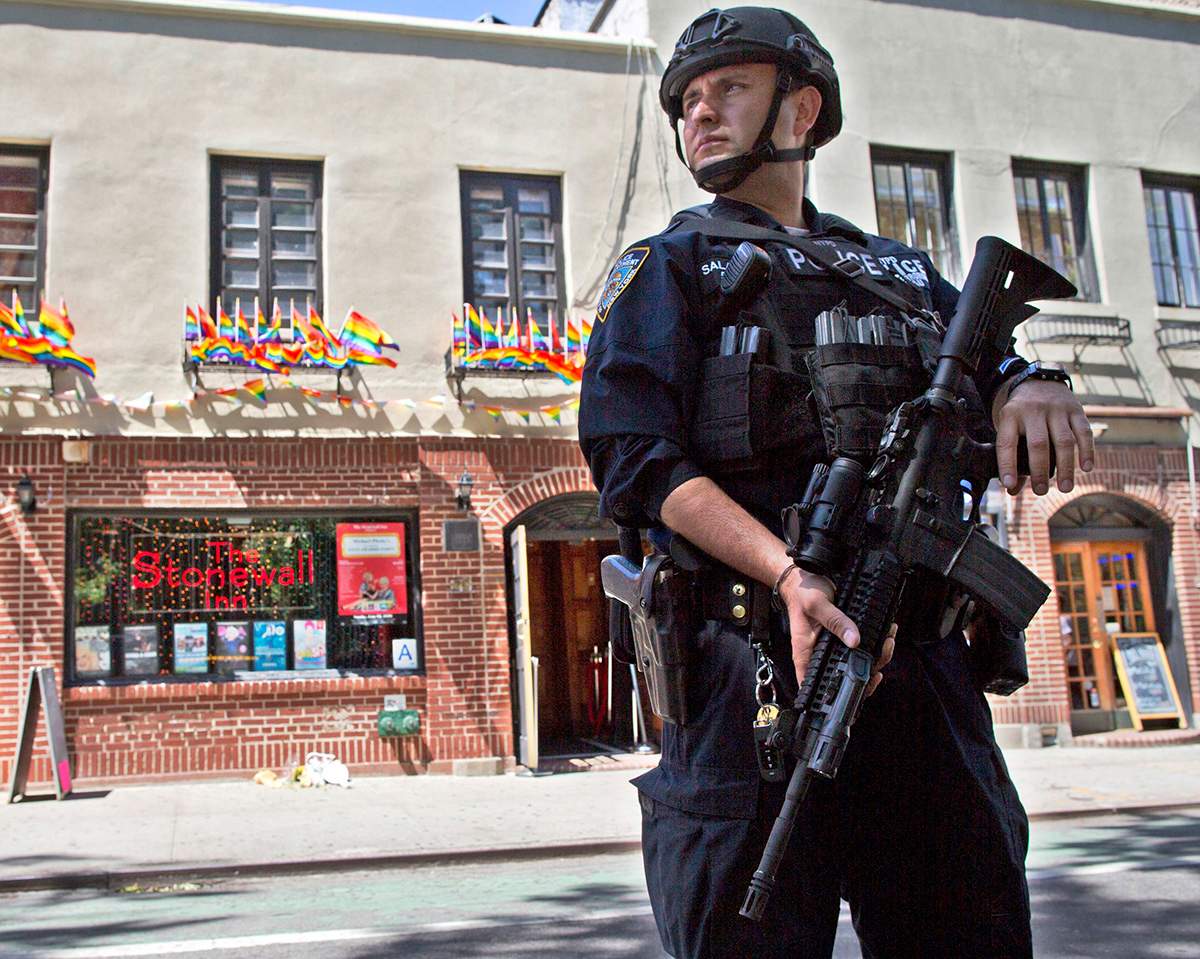 In this June 12, 2016 file photo, an armed police officer stands guard outside the Stonewall Inn, in New York after a Florida gunman's attack at a gay nightclub spread fear of more attacks. 