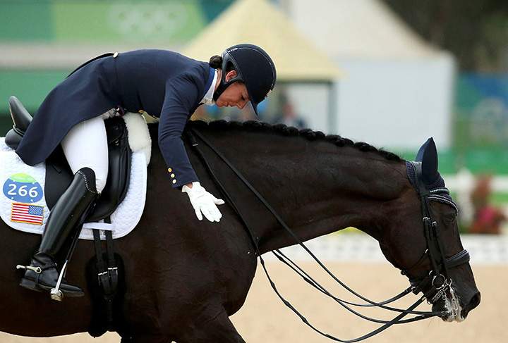 Kasey Perry-Glass of the U.S. hugs her horse Dublet after their preliminary team grand prix event.