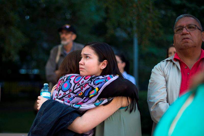 Sarah Fleming hugs her cousin and stands next to her father who are ’60s Scoop survivors at a rally in Toronto on Tuesday, August 23, 2016. Scores of aboriginals from across Ontario rallied in Toronto today ahead of a landmark court hearing on the so-called ’60s Scoop.