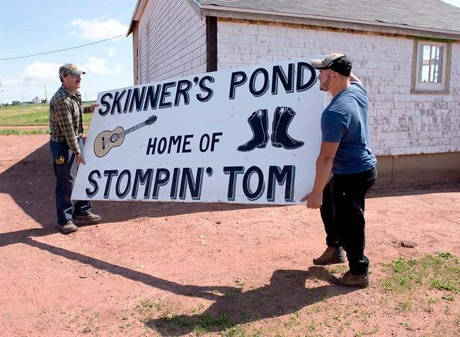 Workers move a sign at the site of the proposed Stompin Tom Connors cultural centre in Skinners Pond, P.E.I. on Wednesday, Aug. 3, 2016. 