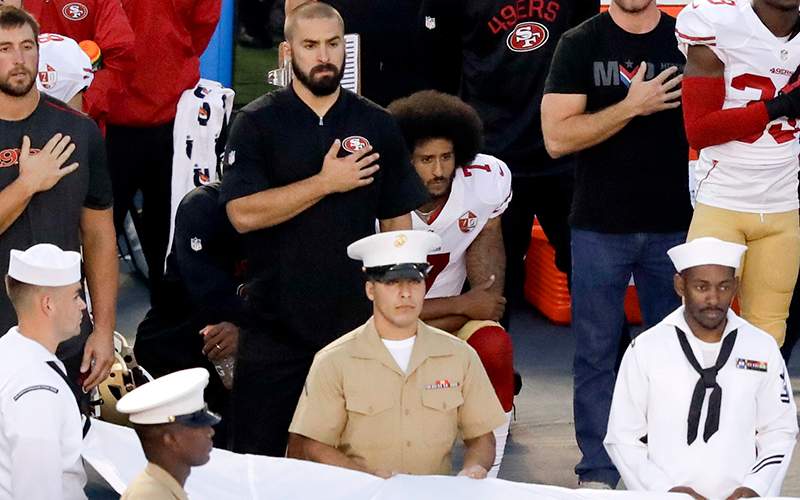 San Francisco 49ers quarterback Colin Kaepernick, middle, kneels during the national anthem before the team's NFL preseason football game against the San Diego Chargers, Thursday, Sept. 1, 2016, in San Diego. 