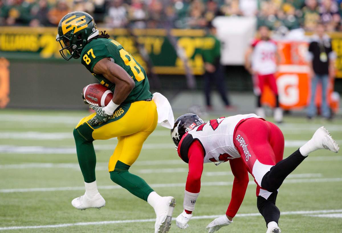 Calgary Stampeders Tommie Campbell (25) tries to stop Edmonton Eskimos Derel Walker (87) as he makes the interception for a touchdown during first half CFL action in Edmonton, Alta., on Saturday September 10, 2016.