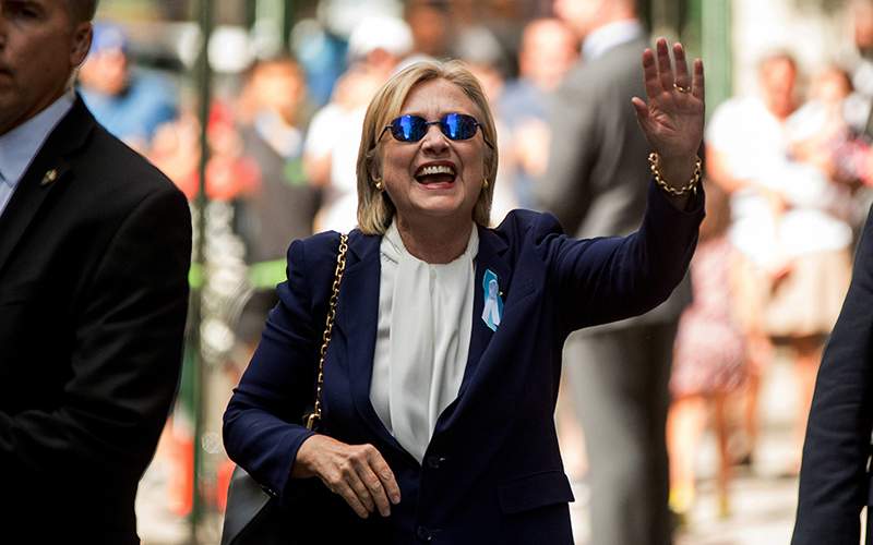 Democratic presidential candidate Hillary Clinton waves after leaving an apartment building Sunday, Sept. 11, 2016, in New York. Clinton's campaign said the Democratic presidential nominee left the 9/11 anniversary ceremony in New York early after feeling "overheated." .