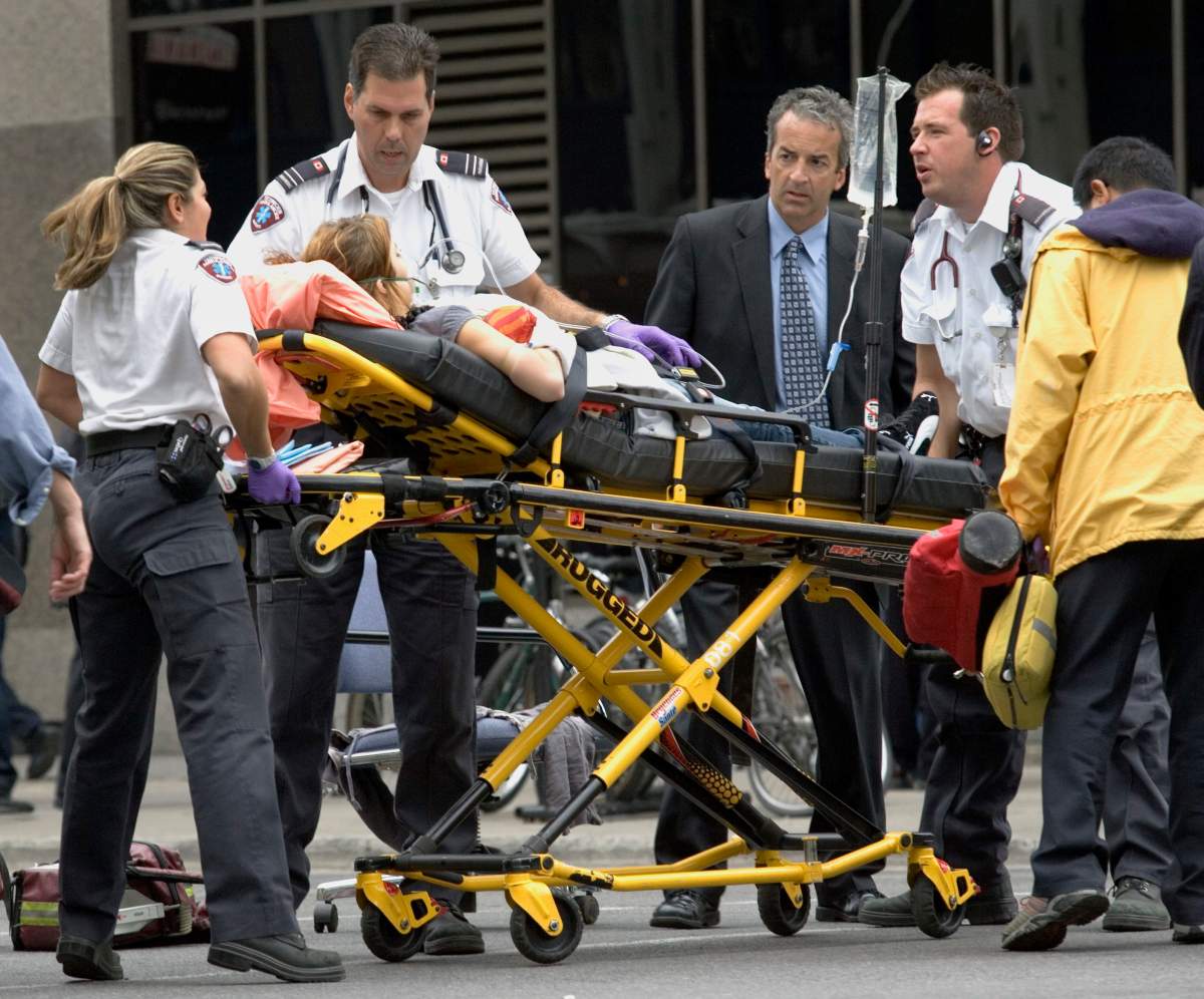 A woman is evacuated during a shooting incident at Dawson College in Montreal, Wednesday, Sept. 13, 2006.