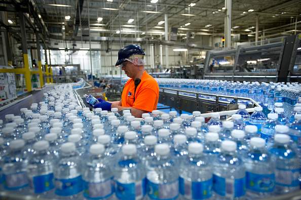 A worker inspects bottles of water at the Nestle Waters Canada plant near Guelph, Ontario, Canada, on Friday, Jan. 16, 2015.  