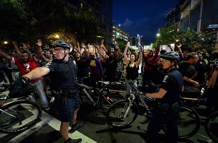 Protesters stop at an intersection blocked by bicycle officers along Trade Street in Charlotte, N.C., Wednesday, Sept. 21, 2016.