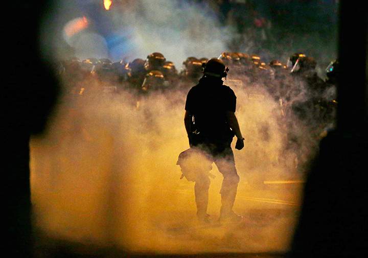 Police fire teargas as protestors converge on downtown following Tuesday’s police shooting of Keith Lamont Scott in Charlotte, N.C., Wednesday, Sept. 21, 2016.