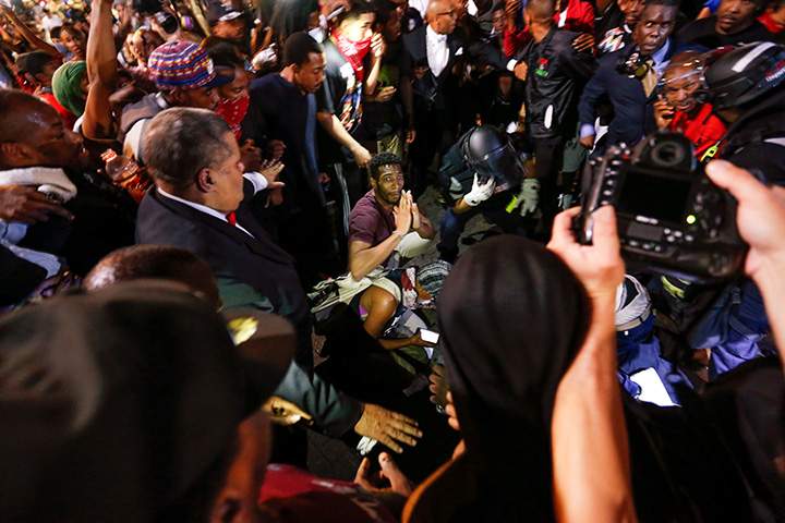 People surround a shooting victim in uptown Charlotte, NC during a protest of the police shooting of Keith Scott, September 21, 2016.