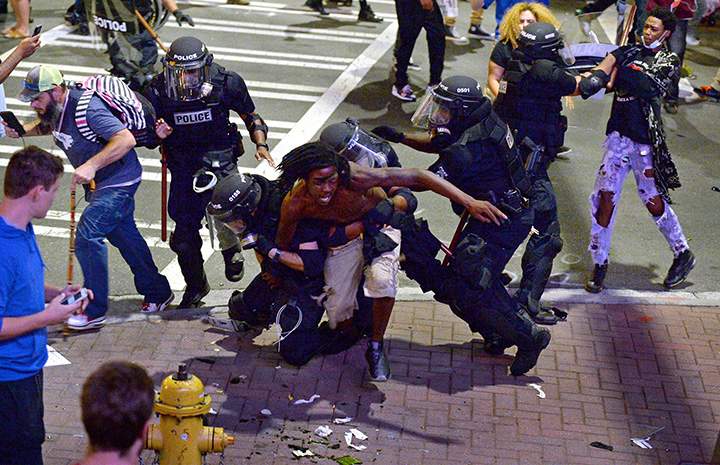 A protester is taken into custody by Charlotte-Mecklenburg police officers in North Carolina, Wednesday, Sept. 21, 2016.