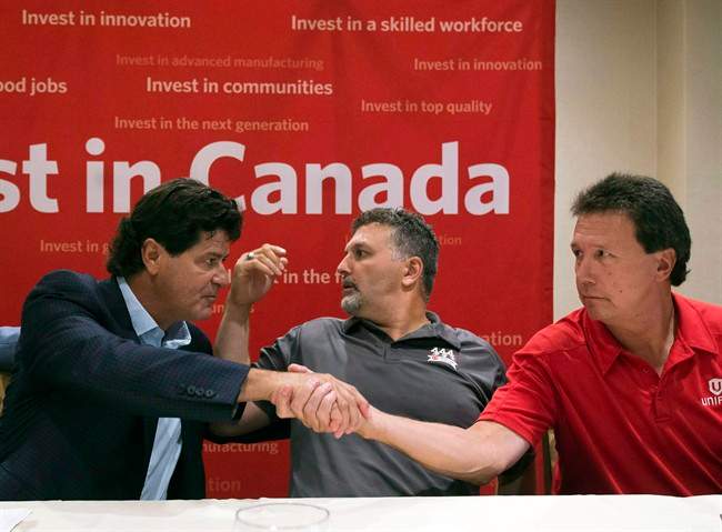 Unifor national president Jerry Dias, left, shakes hands with bargaining committee member Chris Taylor, right, of Ford Motor Company, as bargaining committee member Dino Chiodo, of Fiat Chrysler, sits between them, after the conclusion of a news conference regarding the ongoing Canadian Auto Workers union talks, Thursday, Aug. 11, 2016, in Toronto. 