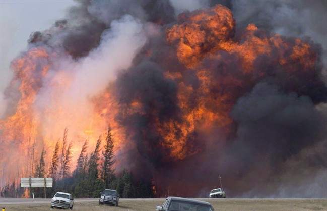 A giant fireball is visible as a wildfire rips through a forest by Highway 63, 16 kilometres south of Fort McMurray, Alta on Saturday, May 7, 2016.